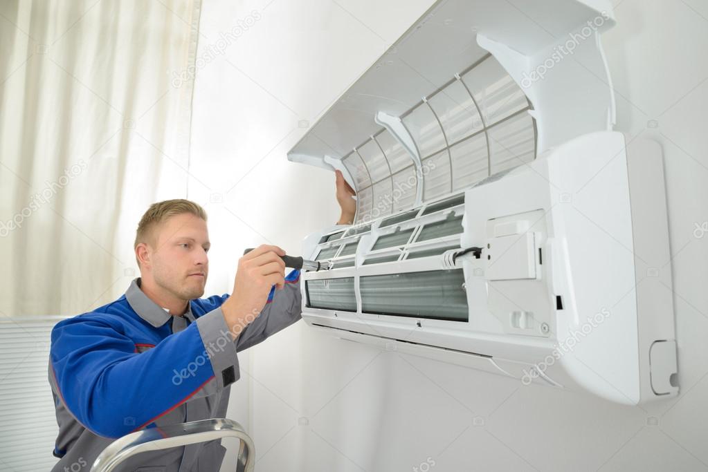 Tecnico che controlla un climatizzatore a parete